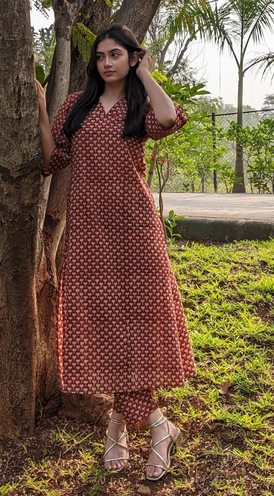Girl standing behind tree wearing lotus print Kurti by neelmii